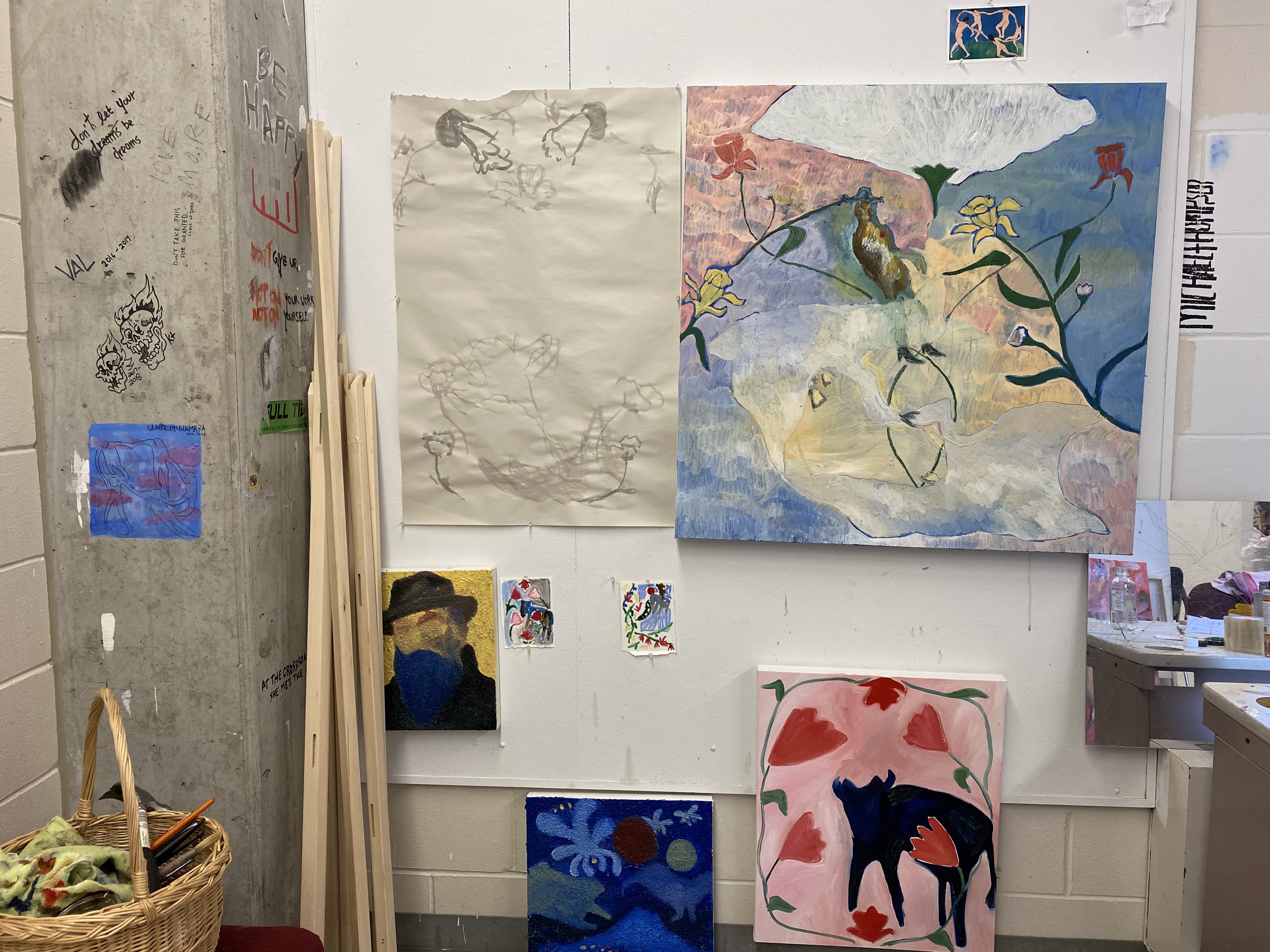 A photo of pieces of art pinned to a wall in a studio.